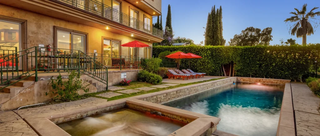 Luxury house with pool and garden at sunset.