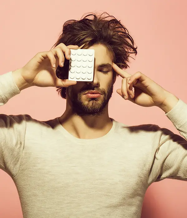 Man with pills blister covers right eye