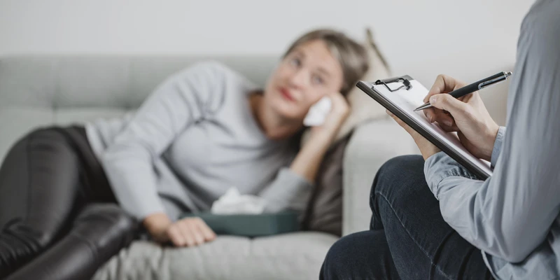 sad woman holding tissue while in therapy
