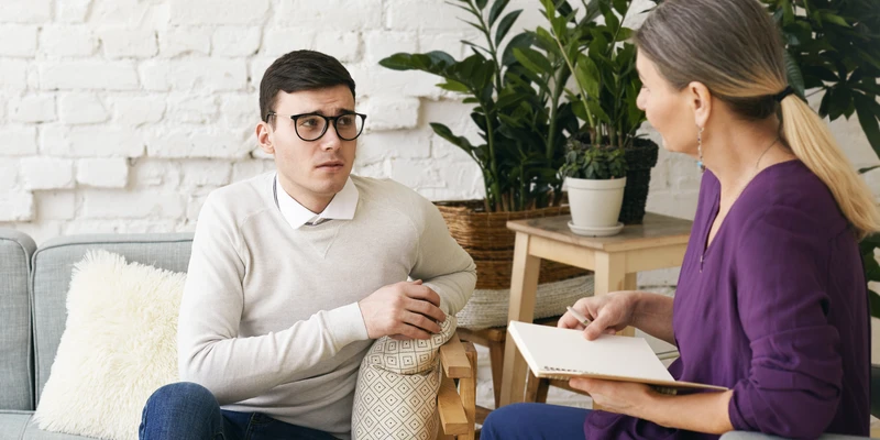 man showing anxious behavior during therapy